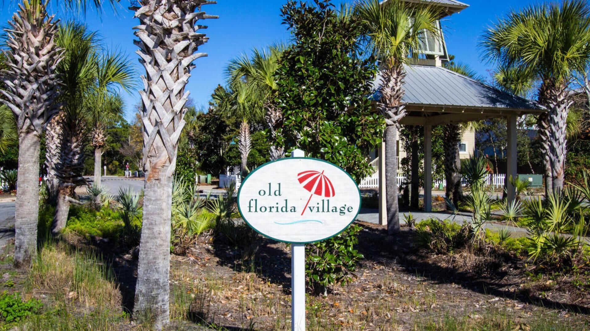 En skylt för Old Florida Village, med en lusthus i bakgrunden.