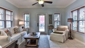 A living room with a sofa, armchair, coffee table, and a ceiling fan. - Monkey Business (Santa Rosa Beach)