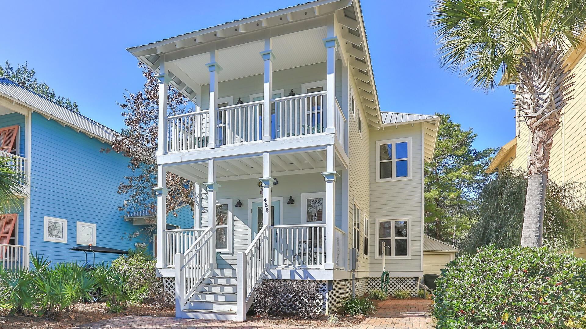 Ein zweistöckiges Haus mit Veranda, Treppe und der Hausnummer 468.