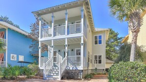 A two-story house with a porch, a staircase, and a number '468' on the front. - Monkey Business (Santa Rosa Beach)