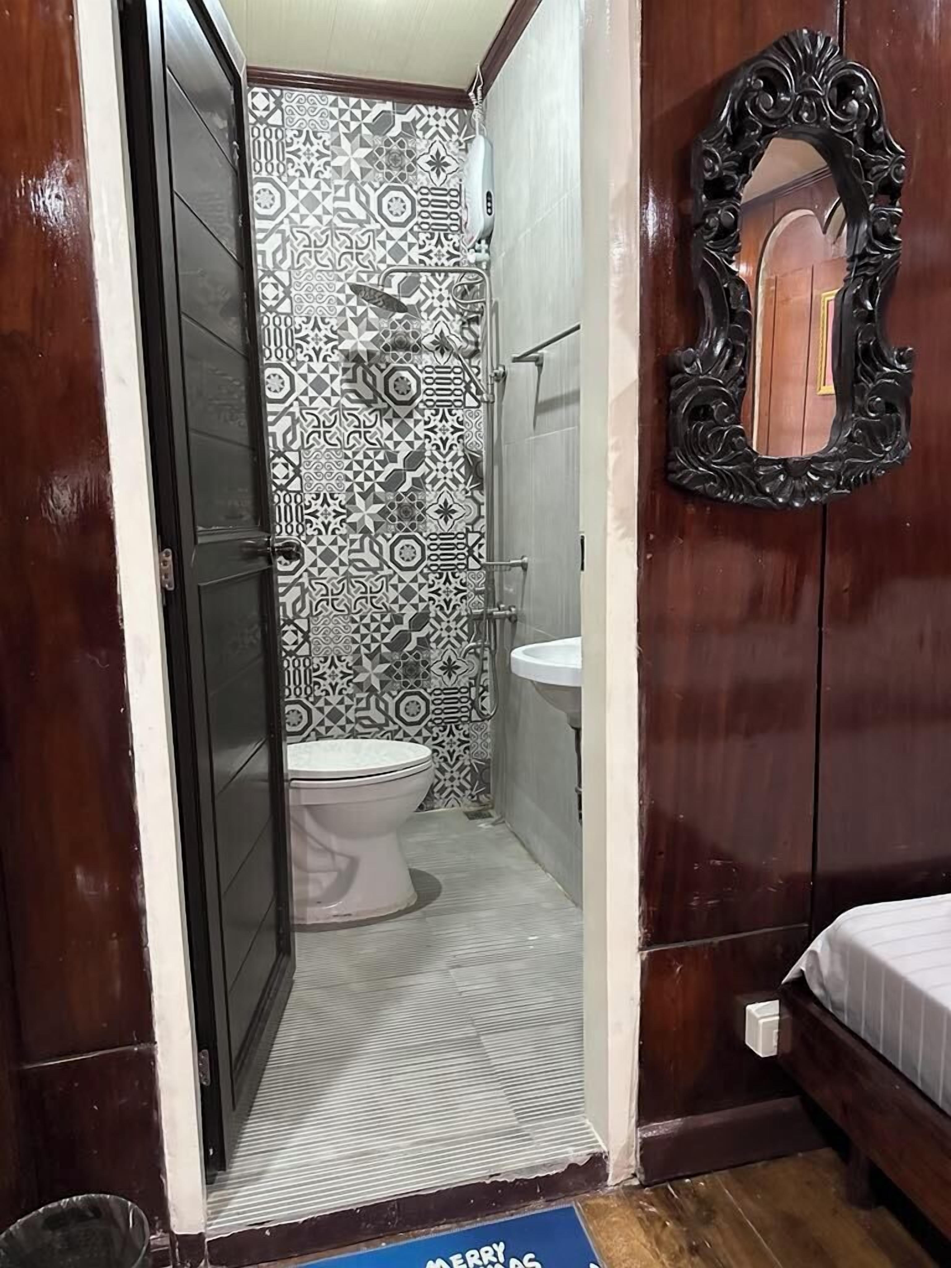 A bathroom with a toilet, sink, and shower.