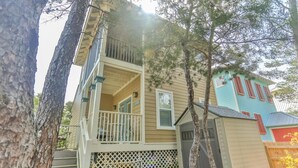 A two-story house with a balcony and a small porch. - Robbins' Nest (Santa Rosa Beach)