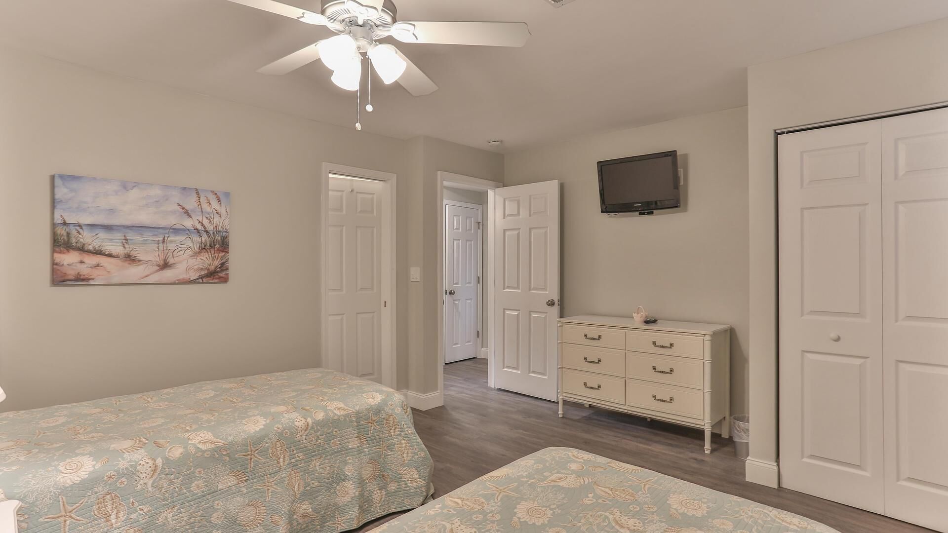Une chambre à coucher avec un lit, une commode et un ventilateur de plafond.