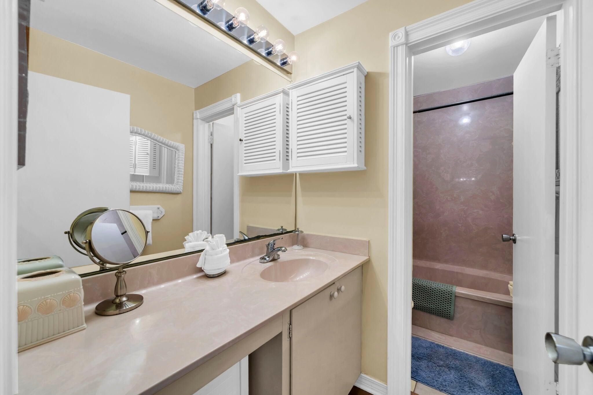 A bathroom with two sinks, a mirror, and a shower.