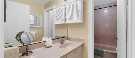 A bathroom with two sinks, a mirror, and a shower.