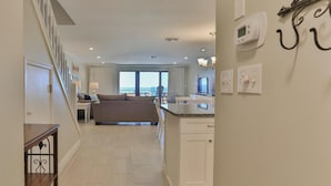 Une chambre d’hôtel moderne dotée d’un balcon, d’une kitchenette et d’une grande fenêtre donnant sur un paysage agréable.