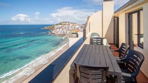 Uma varanda com vista para o mar e uma cidade costeira.