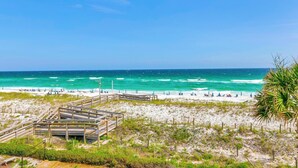 A beach with a wooden boardwalk leading to the shore, sandy beach, and ocean view. - Aegean 309 (Destin)