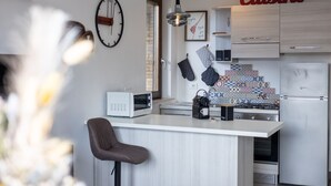 Una cocina moderna con una isla central, microondas, cafetera y refrigerador.