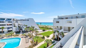 A modern hotel with a pool, beach view, and palm trees. - Aegean 314 (Destin)