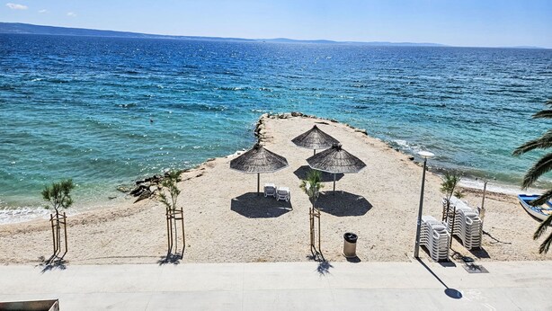 A beach with umbrellas, chairs, and a clear view of the sea. - Jerkan 17 by Interhome (Podstrana)