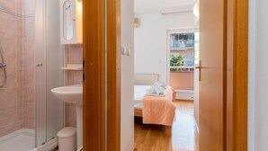 A hotel room with a shower, toilet, sink, and a bed with a view of the balcony. - Jerkan 11 by Interhome (Podstrana)