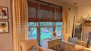 A cozy living room with two armchairs, a small table, and a window with blinds. - Relax and enjoy this Country Charm! (Galena)