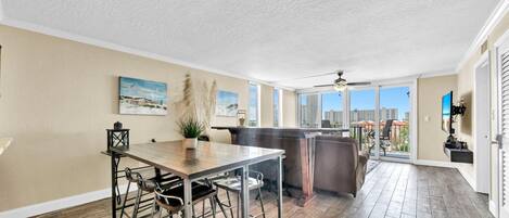 A spacious kitchen with a large island, bar stools, and a view of the city through large windows.