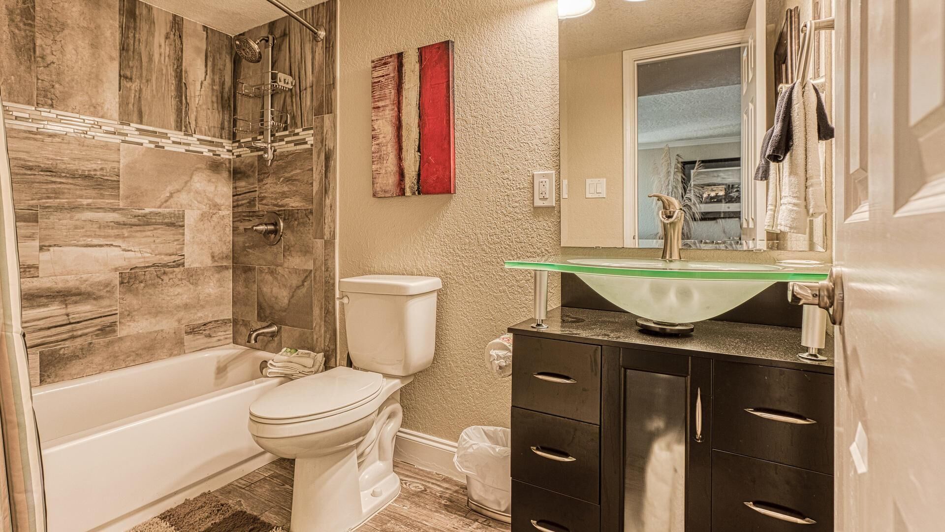 A bathroom with a shower, toilet, and vanity with drawers.