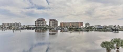 A marina with boats, a waterfront promenade, and several high-rise hotels in the background.