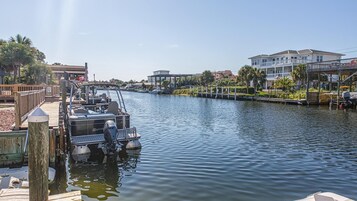 Un puerto deportivo con barcos amarrados, un muelle de madera y edificios a lo largo del agua.