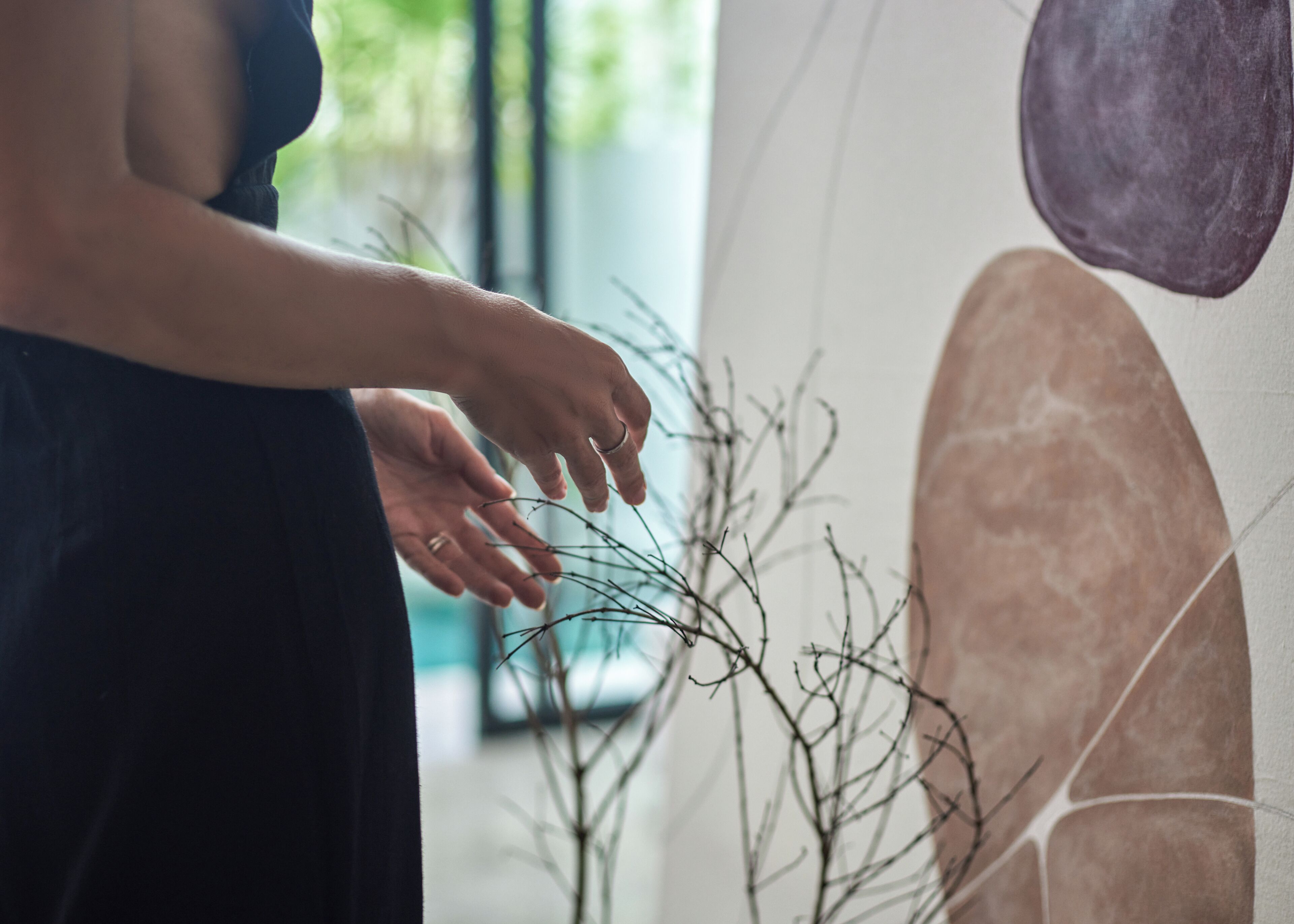 A person reaching out to touch a branch.