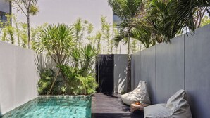 Een modern buitenzwembad met helder water, omgeven door weelderige beplanting en een minimalistisch ontwerp.