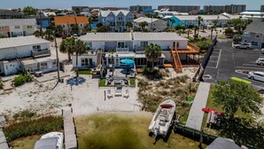 Una propiedad frente al mar con una casa grande, piscina y muelle para embarcaciones.