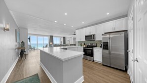 Una cocina moderna con armarios blancos, electrodomésticos de acero inoxidable y una isla grande.