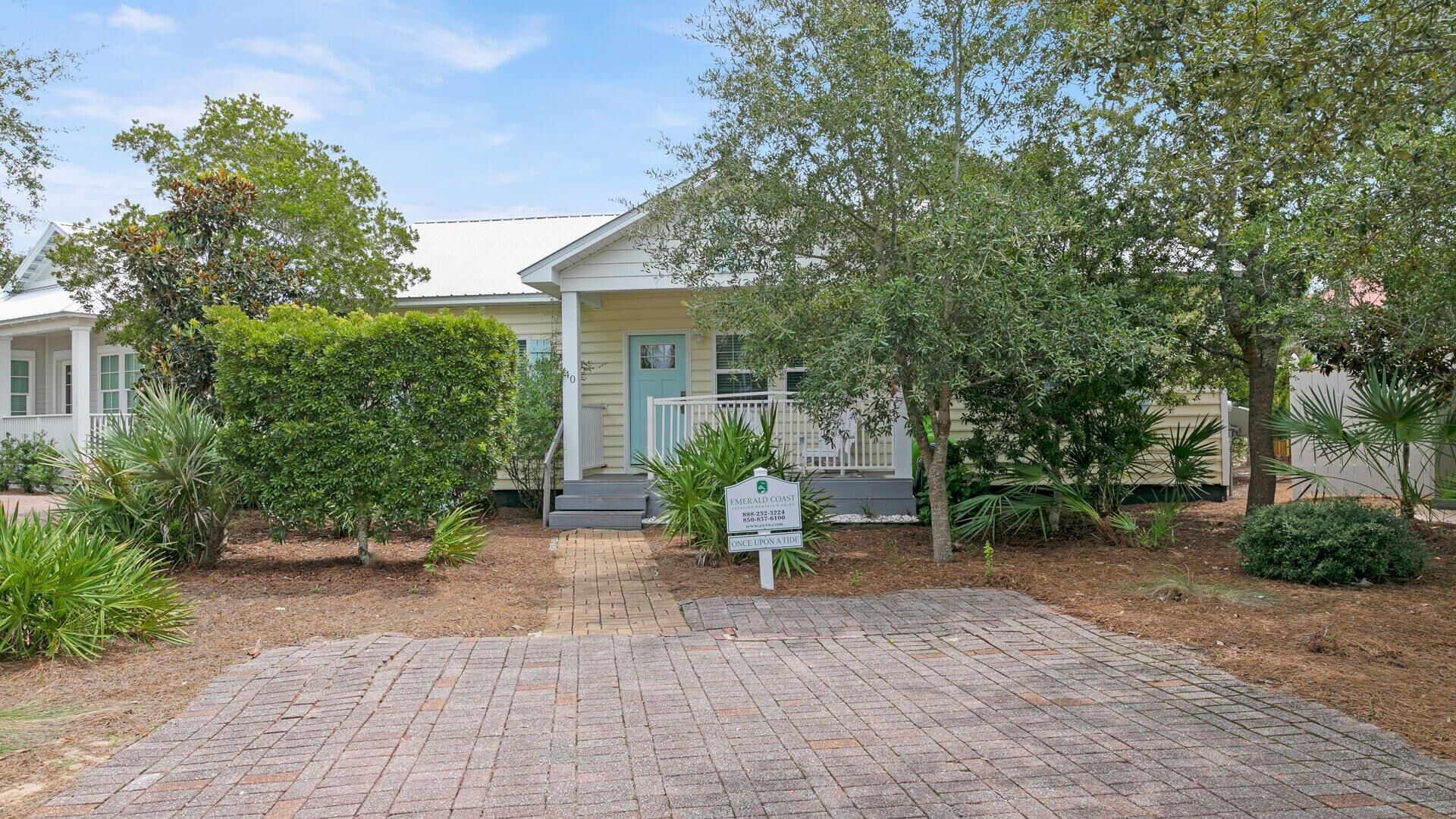 A residential property with a paved driveway, a front porch, and a mailbox.