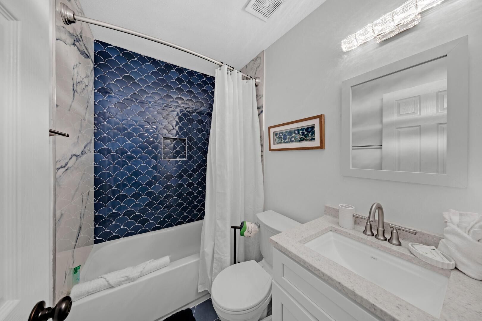 A bathroom with a bathtub, toilet, and sink.