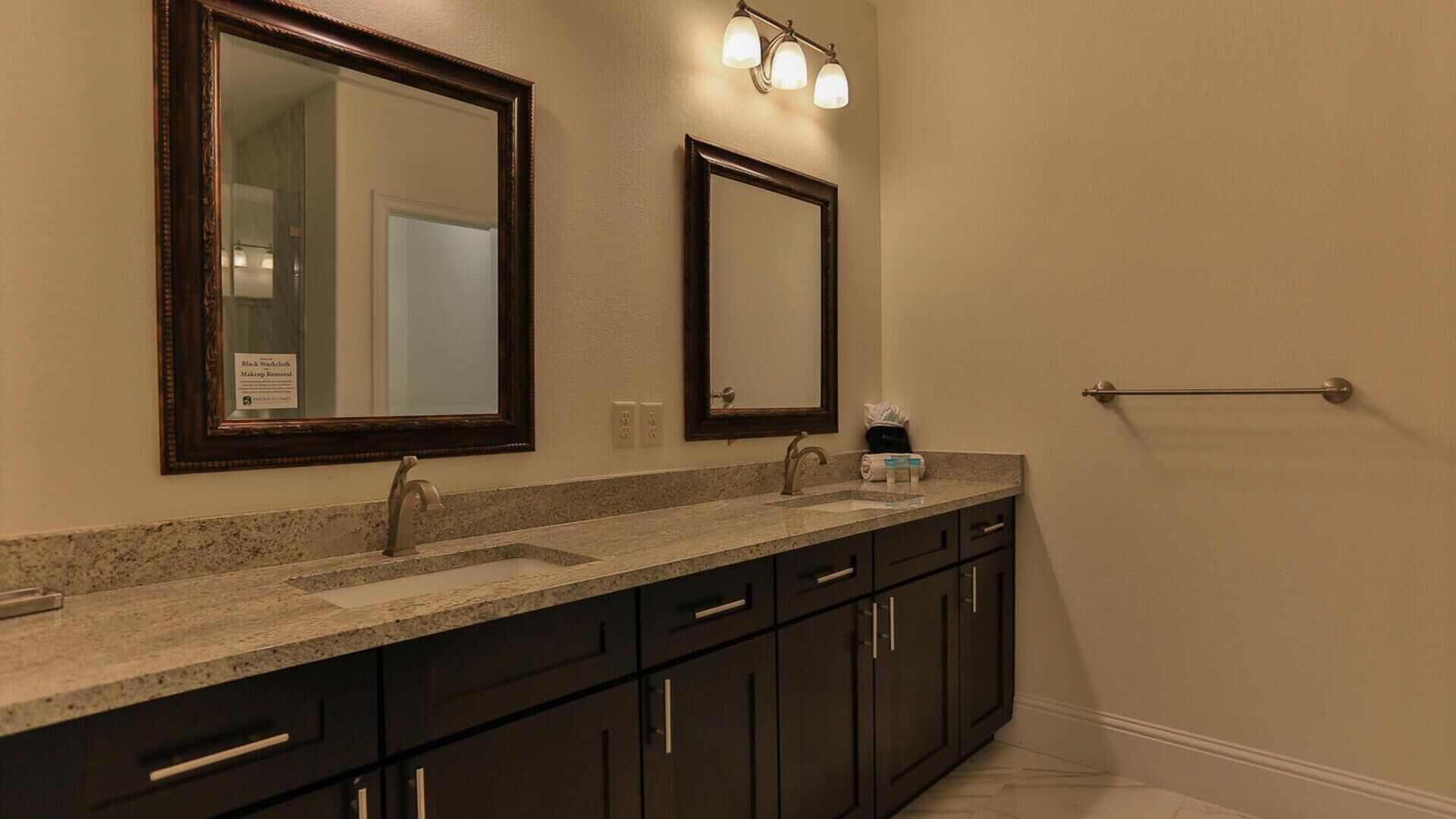 A bathroom with two mirrors, a sink, and a towel rack.