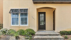 A building with a beige exterior, a black door, and a small porch with steps. - Playa Blanca (Miramar Beach)