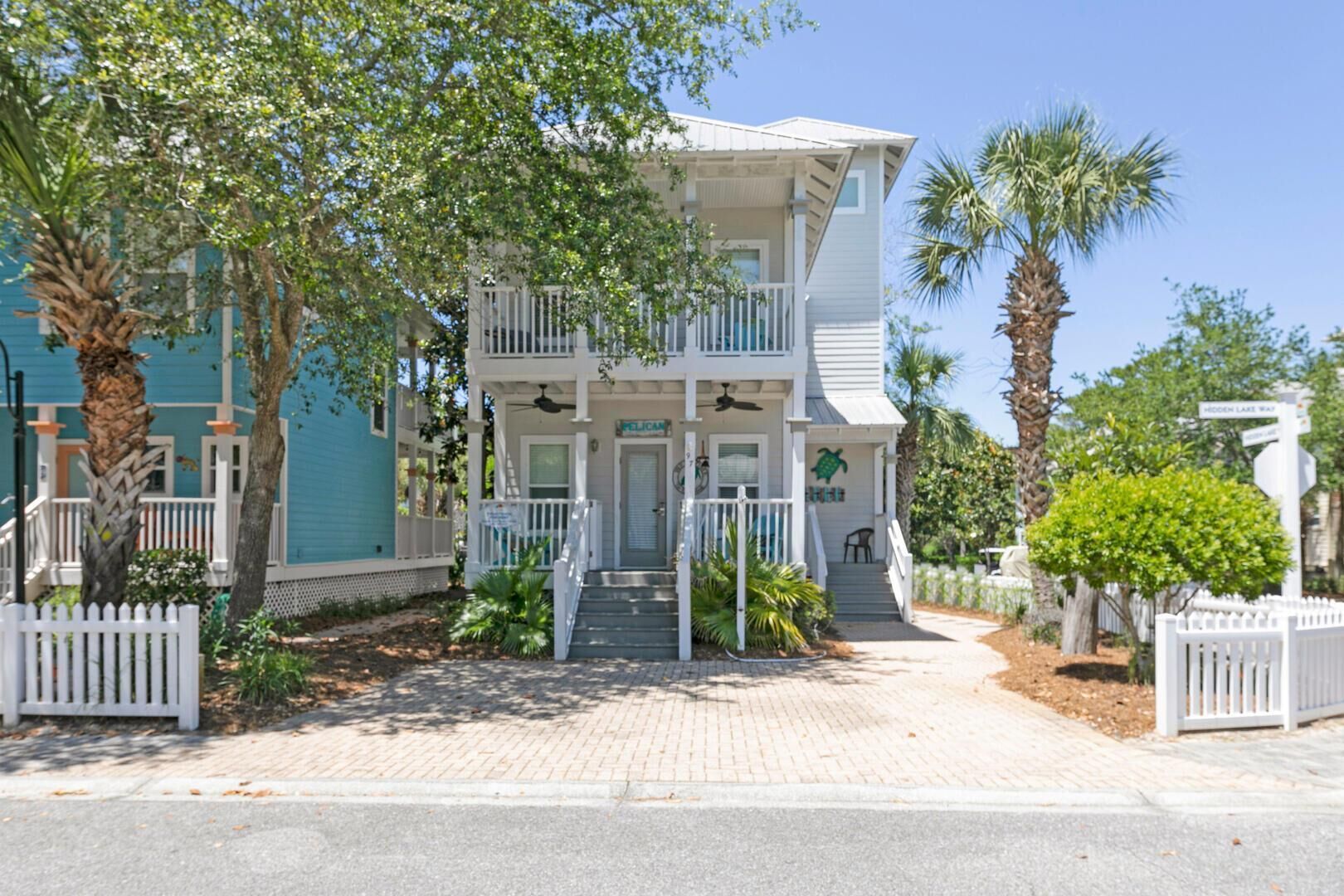 A two-story house with a balcony, a front porch, and a small garden area.