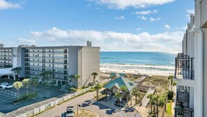 Un hôtel situé en bord de mer, avec plusieurs étages, un parking et une vue sur l’océan.