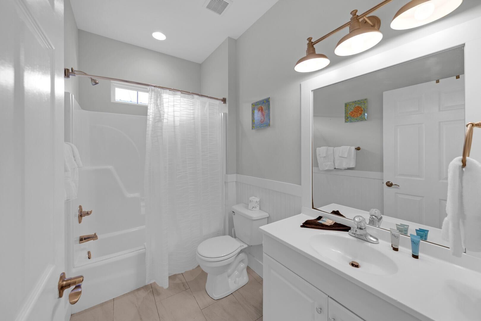 A modern bathroom with a bathtub, toilet, and sink.