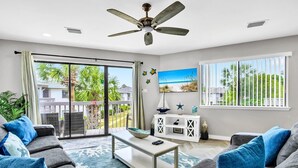 A living room with a balcony, grey sofas, a ceiling fan, and a view of the outdoors. - Crystal Village II, Unit 6B (Miramar Beach)