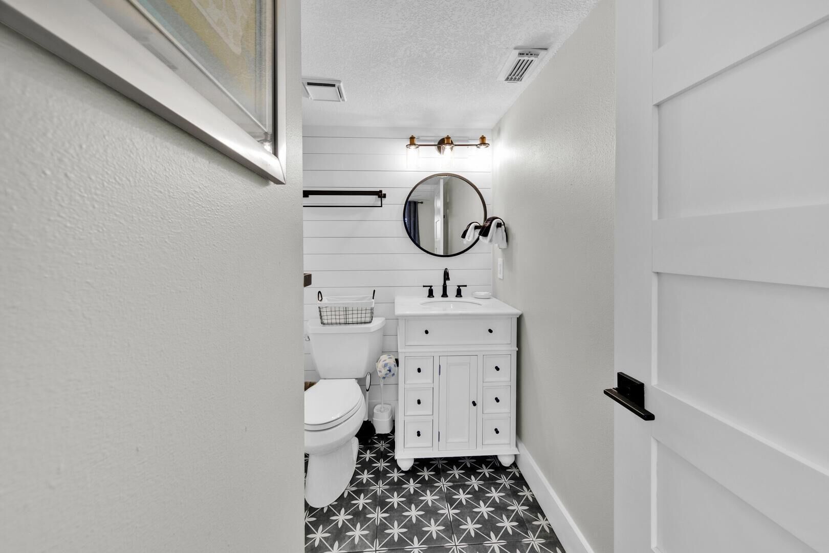 Un baño estrecho con inodoro, lavabo y espejo.