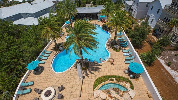 Ein Resort mit einem großen zentralen Pool, kleineren Pools und einer runden Sitzgruppe.