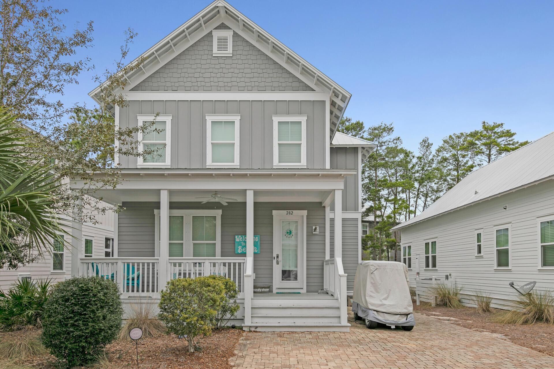 A two-story house with a front porch, a covered porch area, and a mailbox.