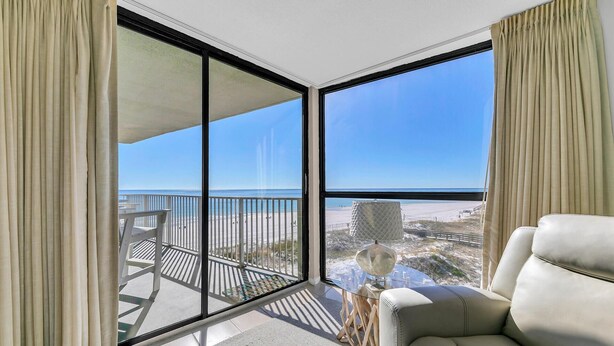 A balcony with a view of the beach, a sofa, and a lamp. - Mainsail 131 (Miramar Beach)