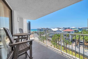 A balcony with a view of the ocean and neighboring buildings. - Mainsail 443 (Miramar Beach)