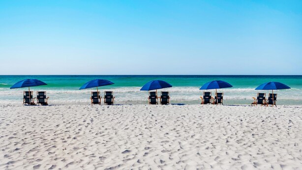 A beach with five rows of beach chairs and umbrellas, facing the ocean. - Silver Beach Towers - Penthouse106e (Destin)