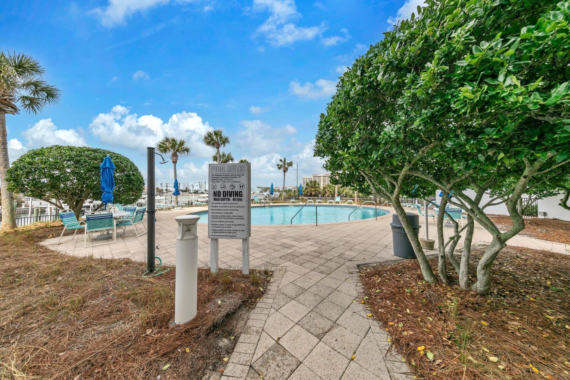 A pool area with a sign detailing pool rules, including no diving and a maximum depth of 4 feet.