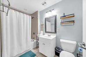 A bathroom with a shower, a sink, a toilet, and a mirror. - Destin West Gulfside 205 (Fort Walton Beach)