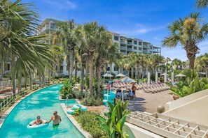 A resort pool area with a clear blue pool, lounge chairs, and palm trees. - Destin West Gulfside 205 (Fort Walton Beach)