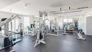 A gym with various exercise machines, mirrors, and a ceiling-mounted pull-up bar. - Destin West Gulfside 304 (Fort Walton Beach)