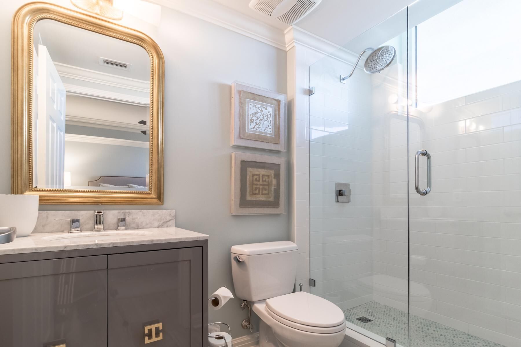 A modern bathroom with a vanity, toilet, and glass shower enclosure.