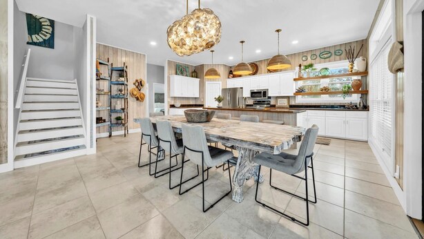A modern kitchen with a central island, white cabinetry, and pendant lighting. - Cloud Nine (Santa Rosa Beach)