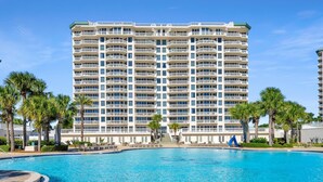 A multi-story hotel with balconies, a swimming pool, and palm trees. - St. Croix 206 at Silver Shells (Destin)