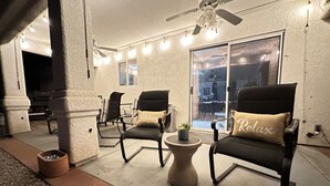 An outdoor seating area with two chairs, a small table, and a ceiling fan. - Lake View • Hot Tub • RV/Boat Parking • Fire Pit (Lake Havasu City)
