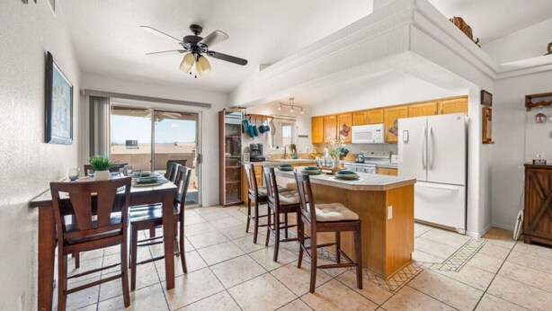 A spacious kitchen with a central island, wooden cabinets, and a ceiling fan. - Lake View • Hot Tub • RV/Boat Parking • Fire Pit (Lake Havasu City)