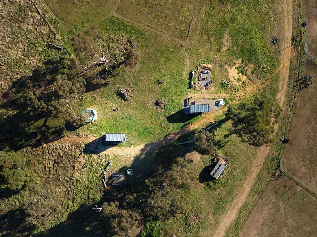 An aerial view of a rural property with multiple buildings, including a main house, a barn, and several smaller structures.