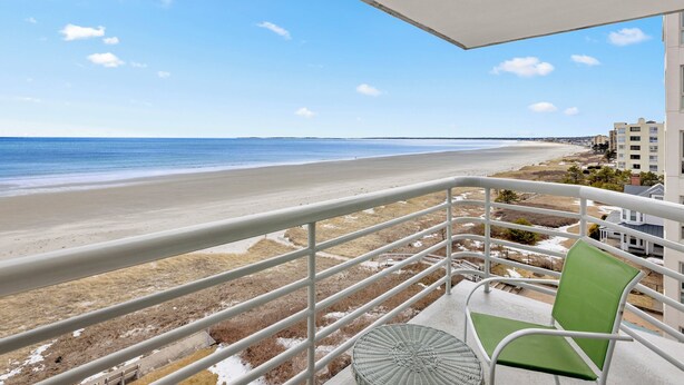 Ein Balkon mit Blick auf einen Strand und das Meer.